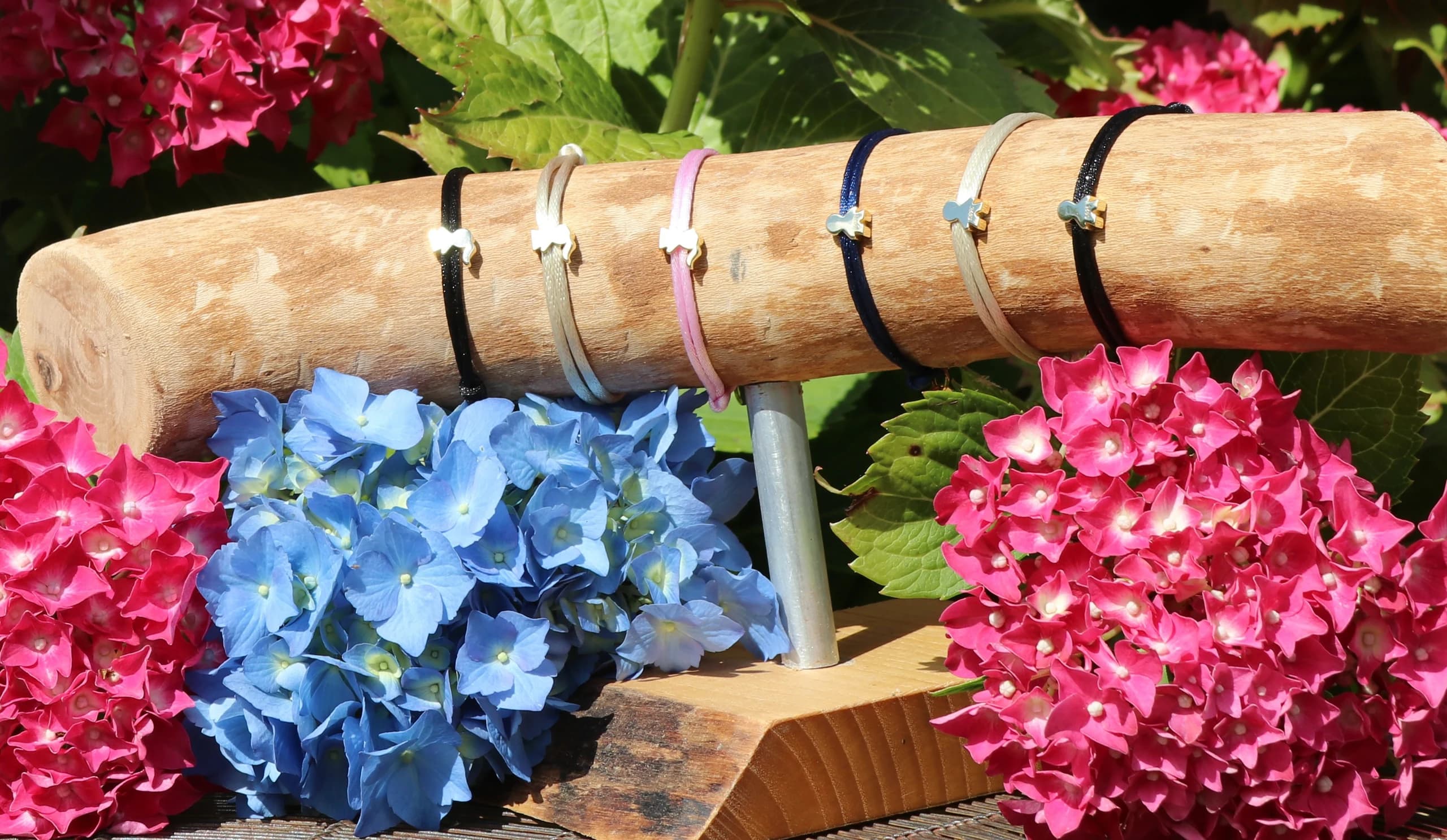 Gaab Forever Love bracelets displayed among pink and blue hydrangeas