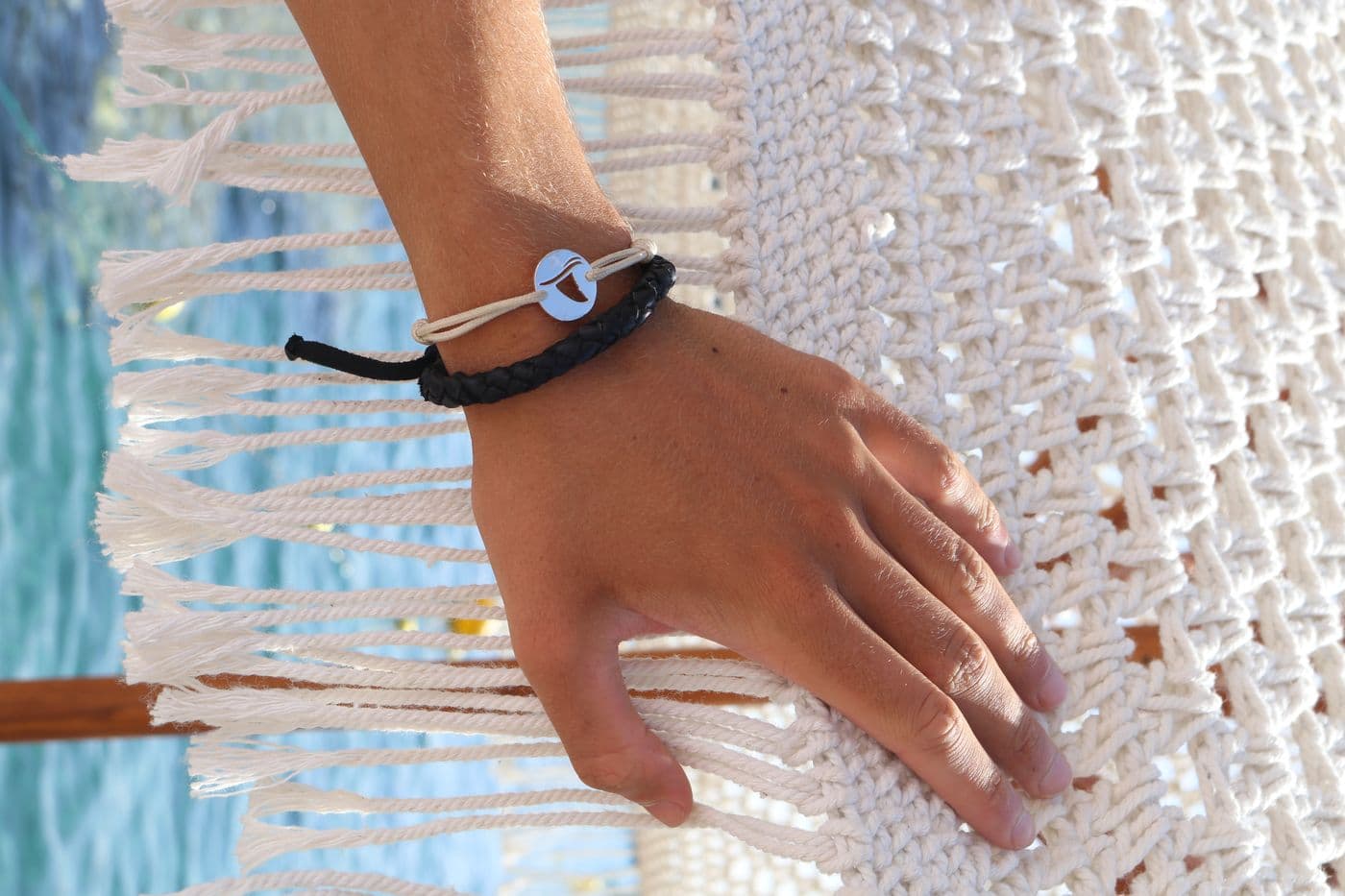 Hand wearing a Gaab bracelet on a macrame hammock