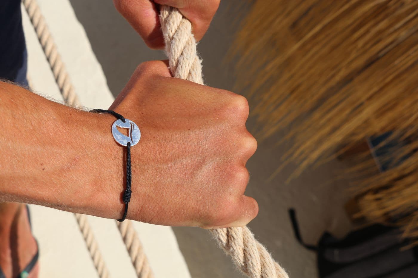 Gaab bracelet worn while gripping a rope on a boat